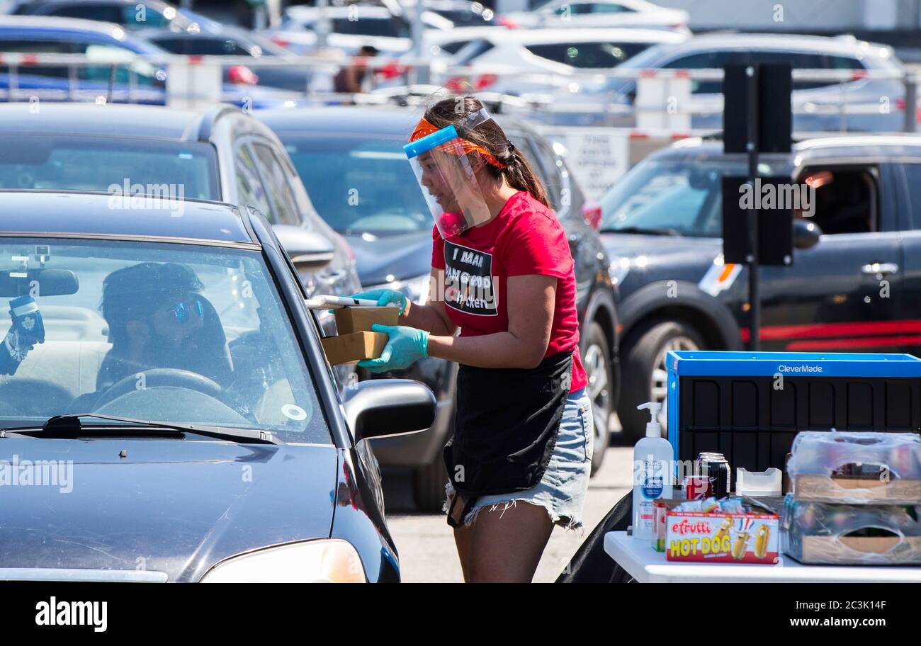 Toronto Canada th June A Staff Member Of A Food Truck Wearing A Face Shield Passes Packaged Food To A Customer During A Drive Thru Food Truck Festival In Toronto Canada On
