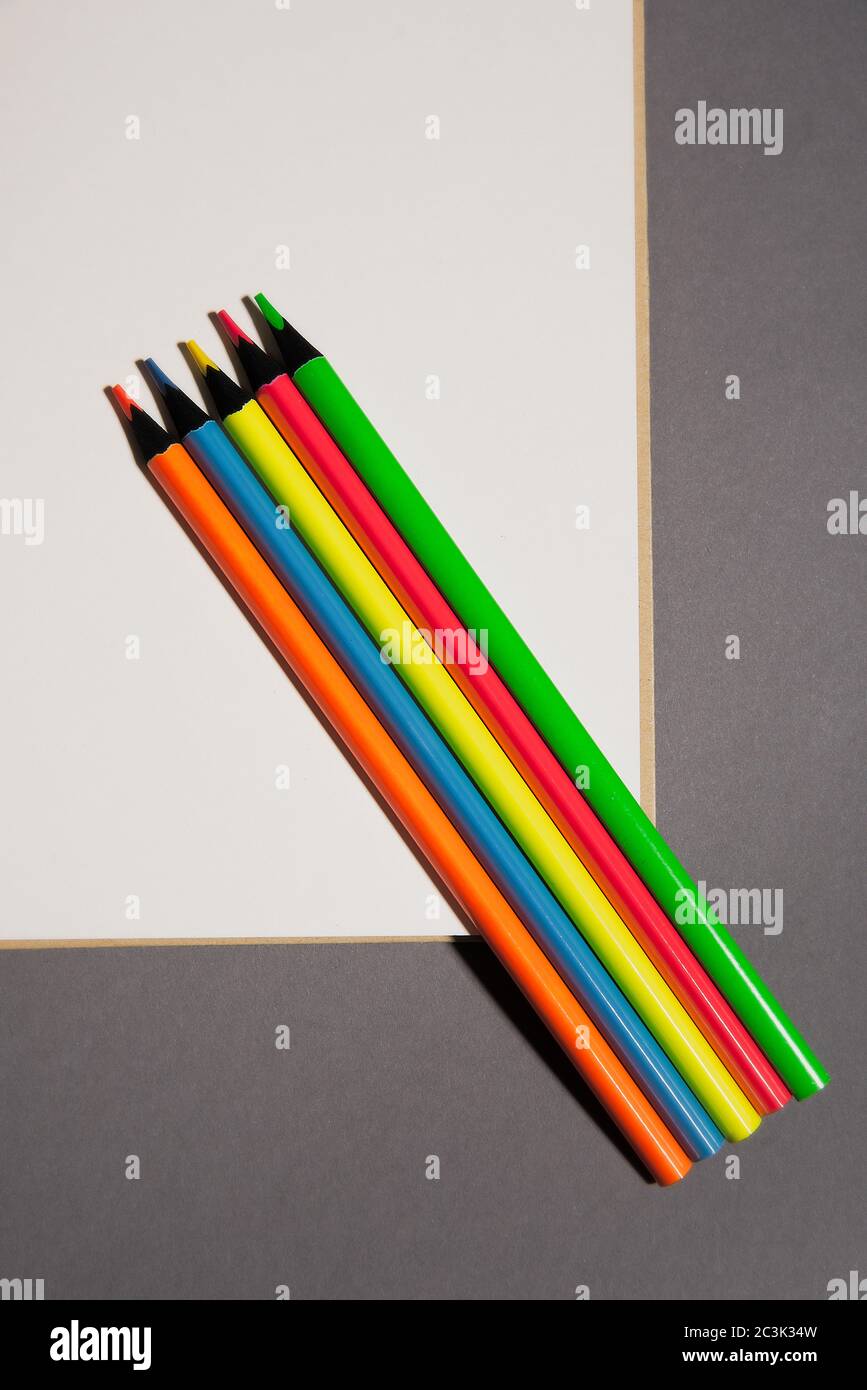 colored pencils lie on white page of  notebook Stock Photo