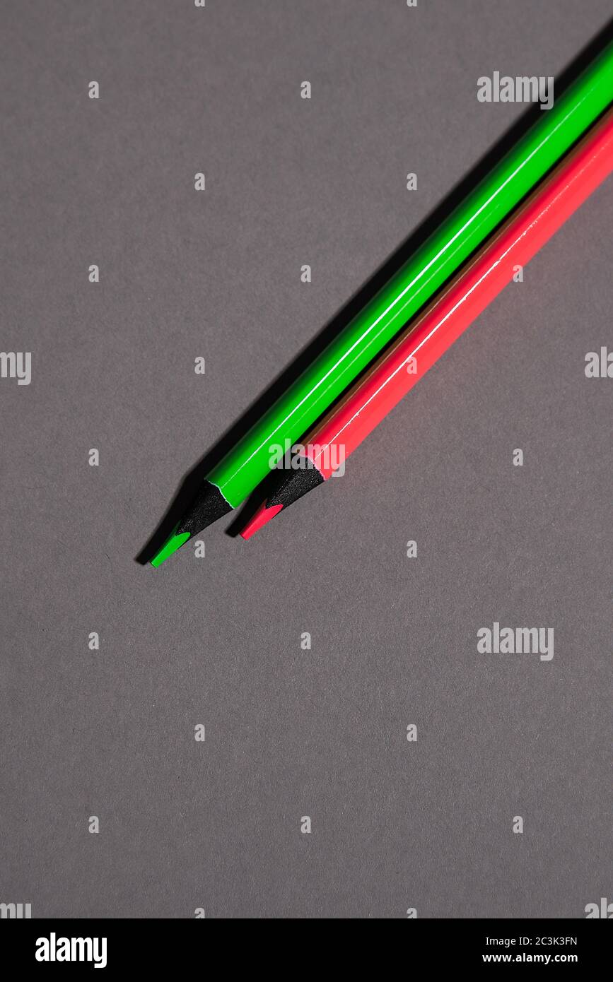 green and red pencil on gray background Stock Photo