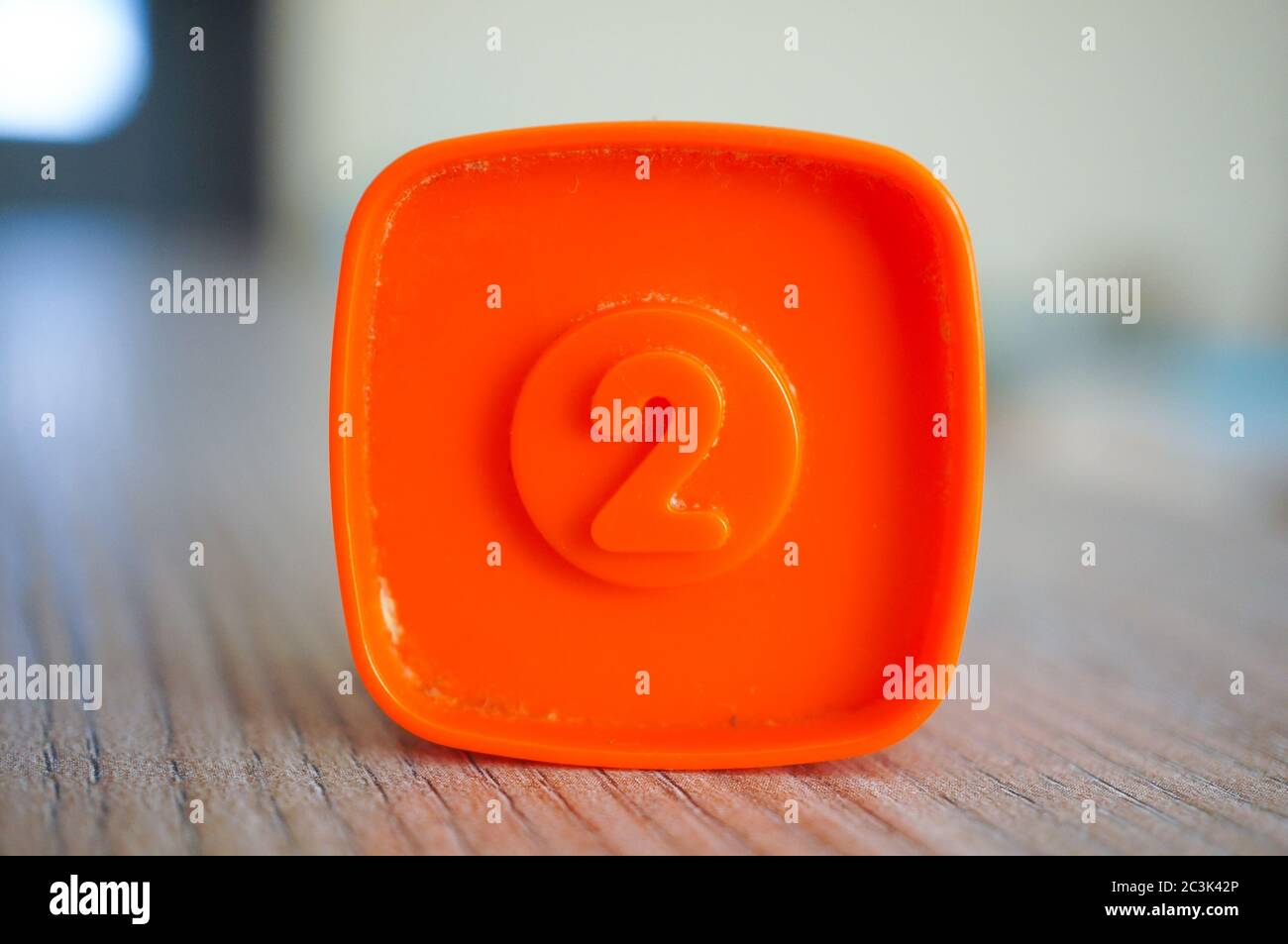 Square Toy Color Closeup shot of an orange plastic square-shaped toy with number two on ...