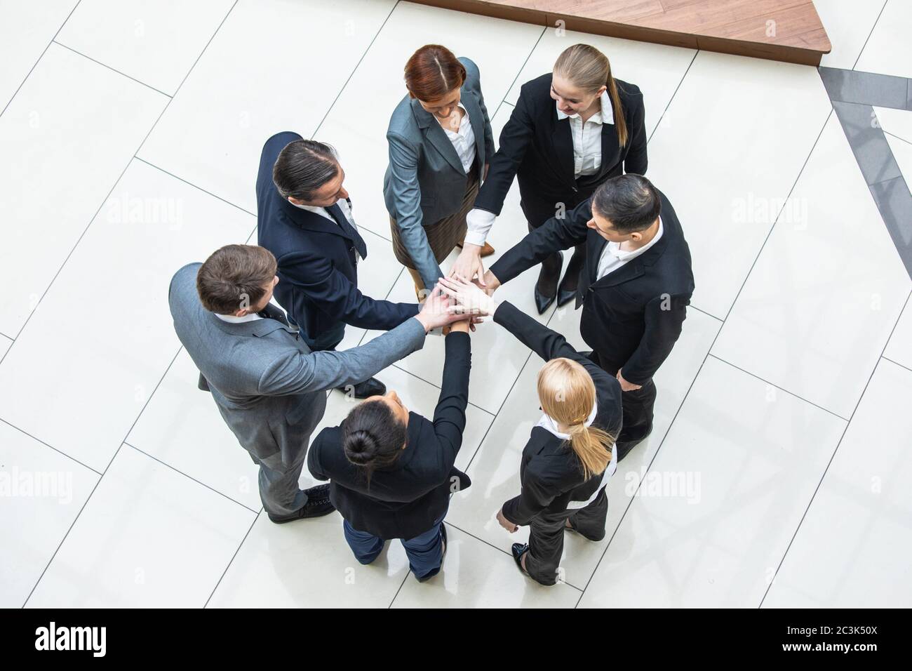Business teamwork concept, coworkers putting hands together in a tower stacking hands unity cooperation concept, top view Stock Photo
