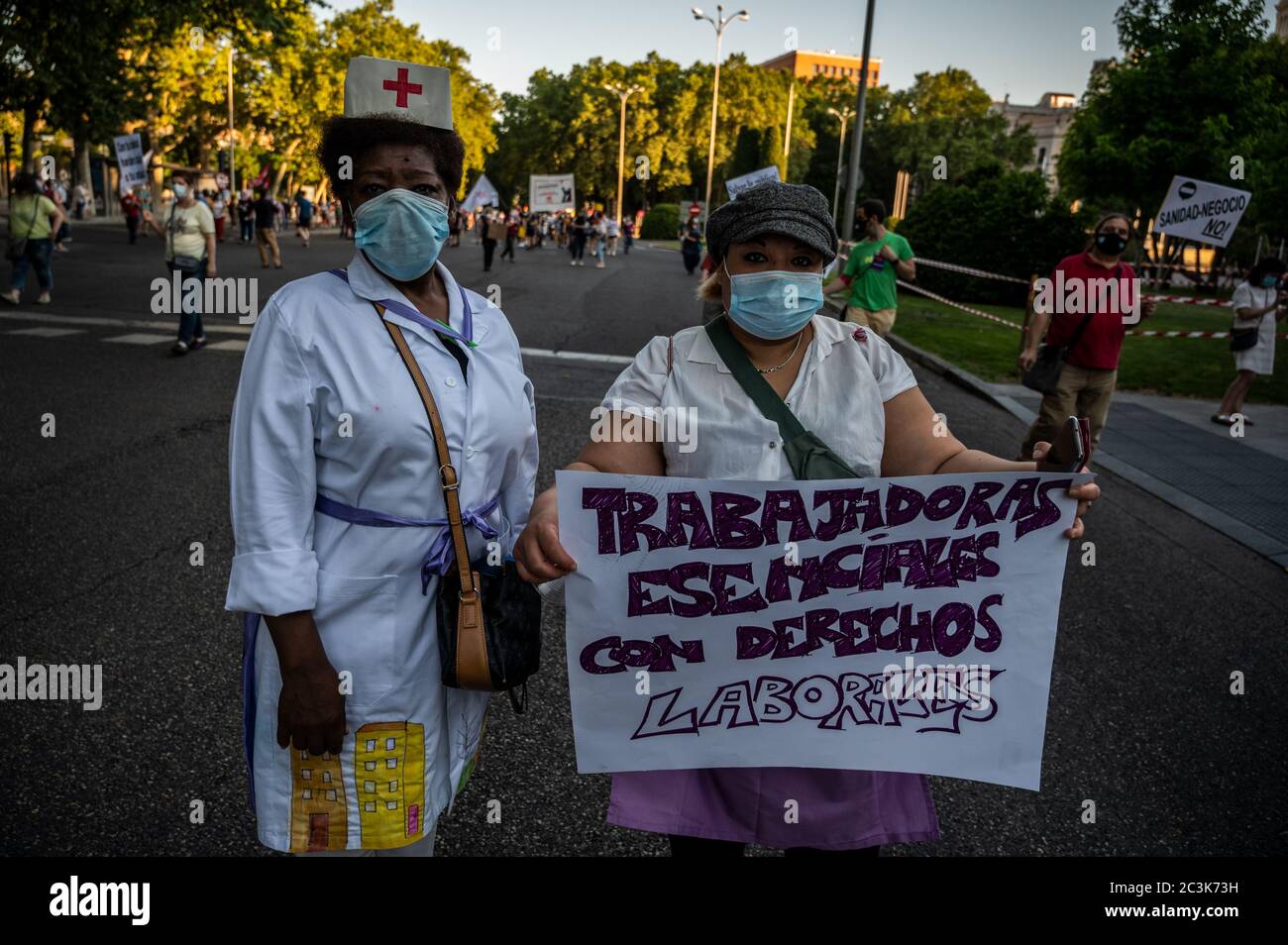 Madrid, Spain. 20th June, 2020. Madrid, Spain. June 20, 2020. A couple of women carrying a placard during a demonstration in support of the public healthcare system and protesting against privatization. Healthcare workers are carrying out protests during the coronavirus crisis against the precariousness of their work. Placard reads: essential workers, with labor rights. Credit: Marcos del Mazo/Alamy Live News Stock Photo