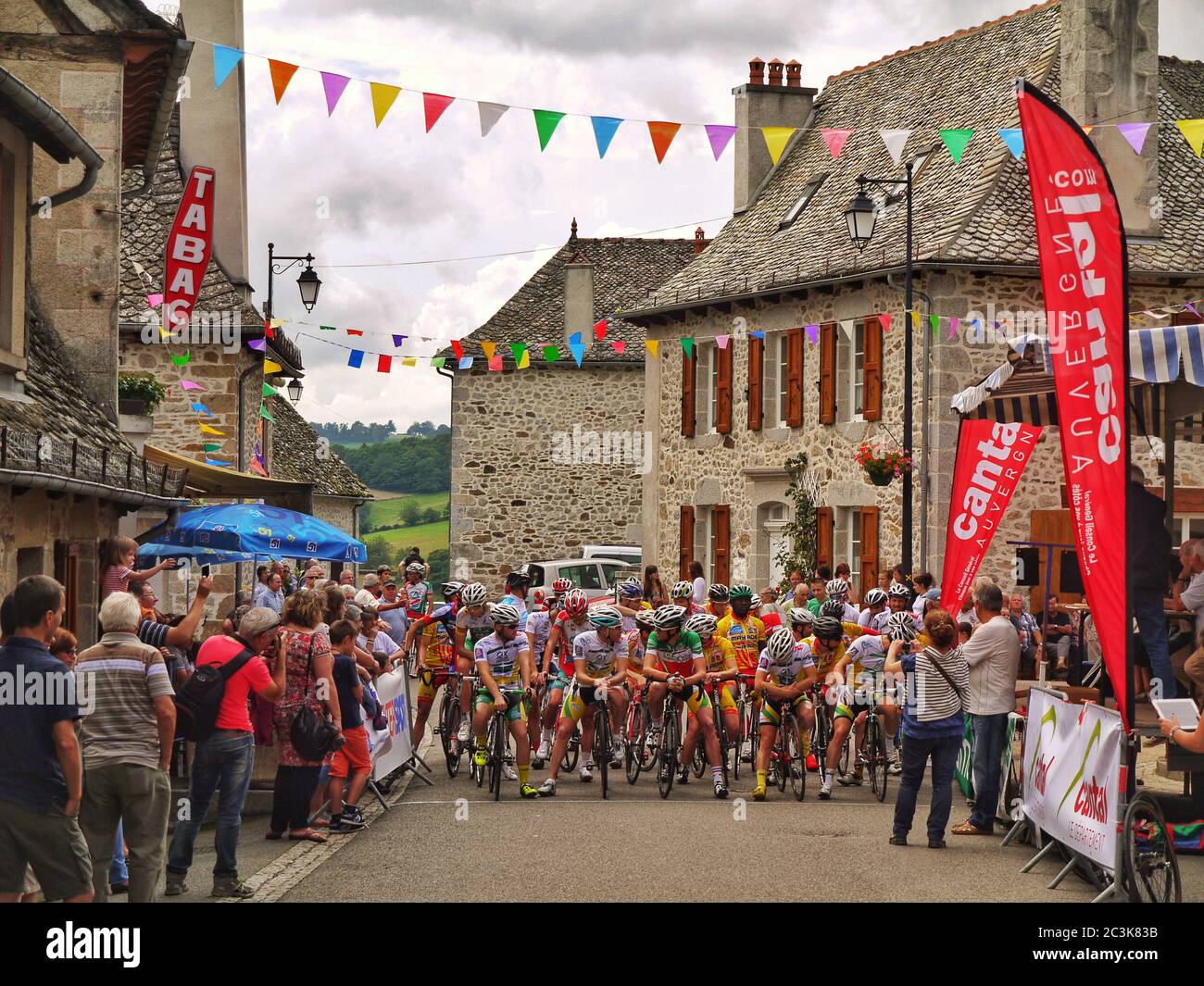 A bicycle race though the French village of Junhac - Auvergne-Rhône-Alpes, Cantal, France Stock Photo