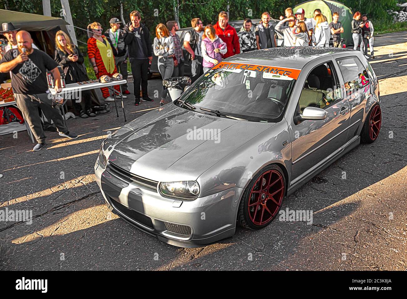 Moscow, Russia - July 19, 2019: Tuned low sport hatchback with red Candy colored alloy wheels. Volkswagen Golf mk 4 is on the street. Stanced lowrider with badboy hood Stock Photo