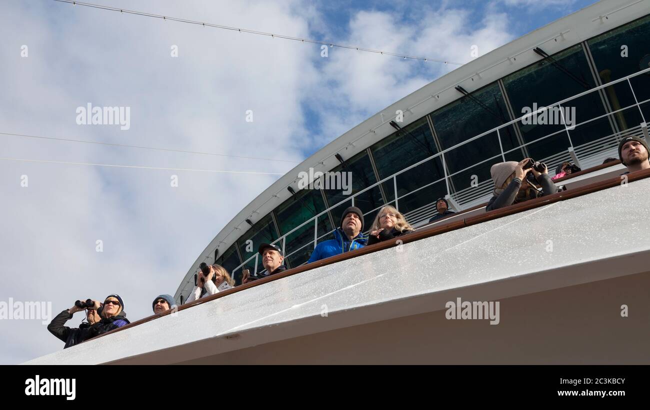 Visitors gathered on the bow of the MS Westerdam cruise ship to view Johns Hopkins Glacier from Johns Hopkins Inlet in Glacier Bay National Park and P Stock Photo