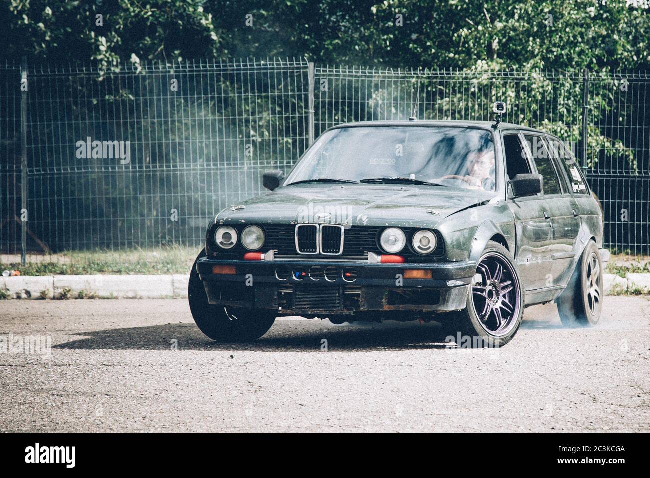 Moscow. Russia - July 06, 2019: A dark BMW car drifts in the parking lot. A lot of smoke, a burnout. Illegal drift. Law violation. Stock Photo