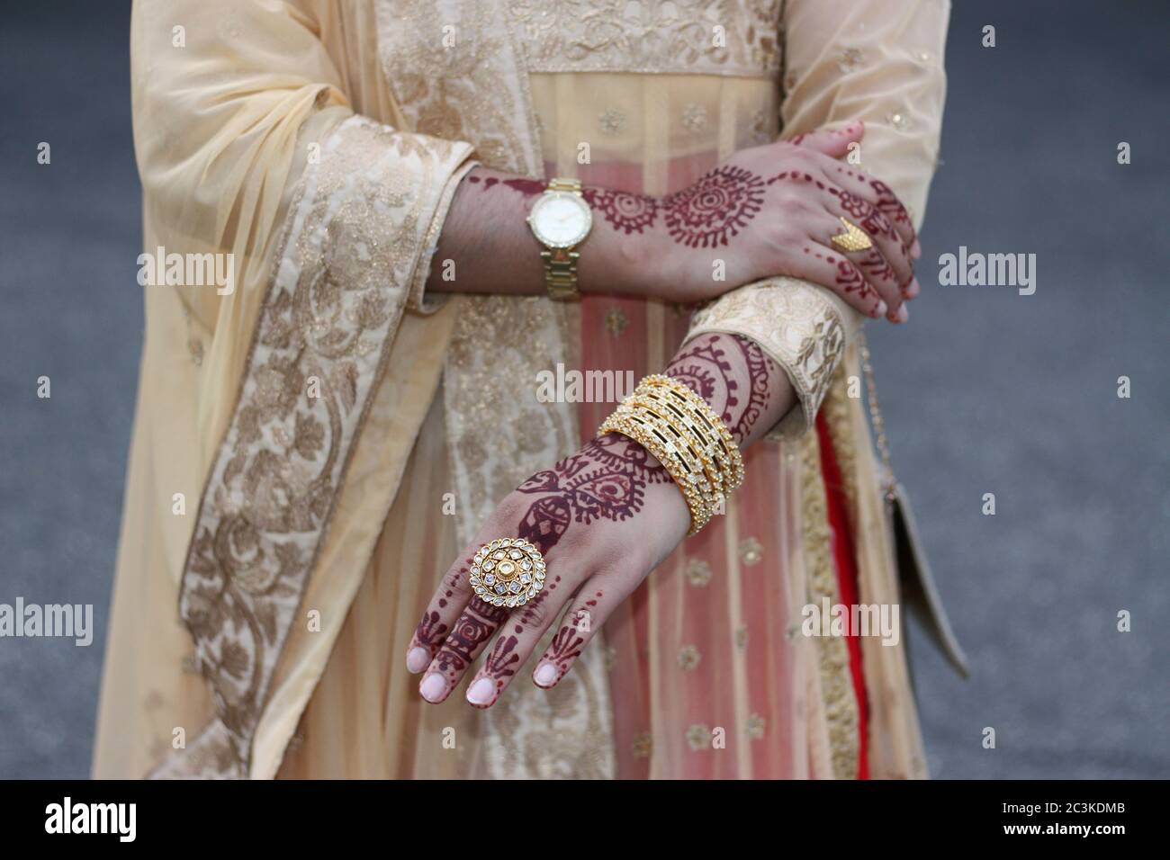 Indian desi woman in weeding dress and henna hands in gold jewelry Stock Photo
