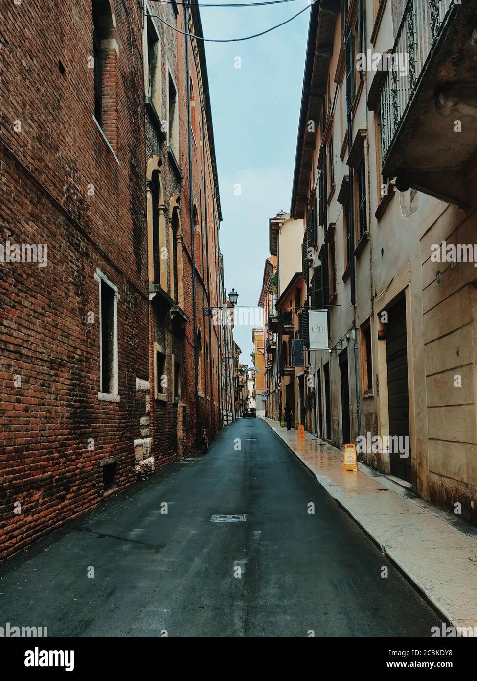Vertical shot of a narrow street with brick buildings with windows ...