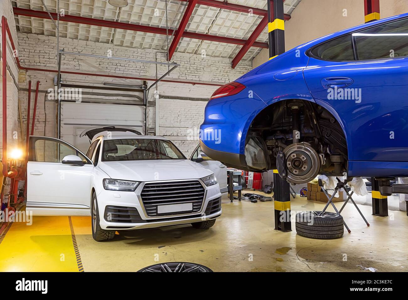 Two cars in the service station on the seasonal change of wheels. Blue
