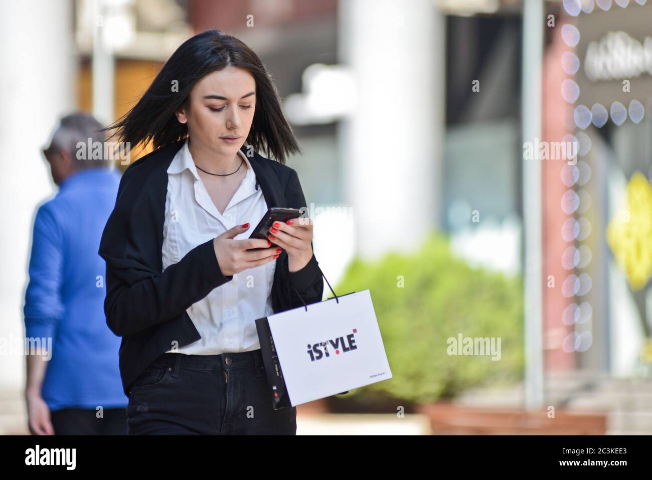 Armenian young woman looking at her cellphone in Northern Avenue, Yerevan, Armenia Stock Photo