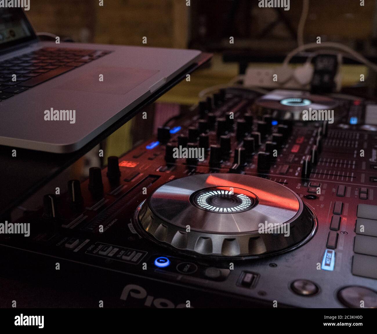 Closeup shot of a DJ mixer with a laptop on top Stock Photo - Alamy