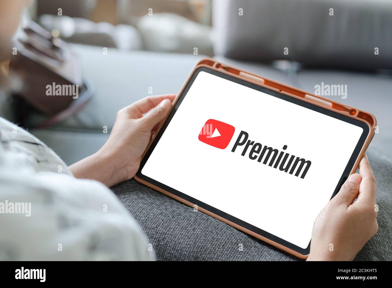 Woman Watching YouTube Premium On iPad ,With YouTube Premium, enjoy ad-free access, downloads, and background play on YouTube and YouTube Music by Stock Photo