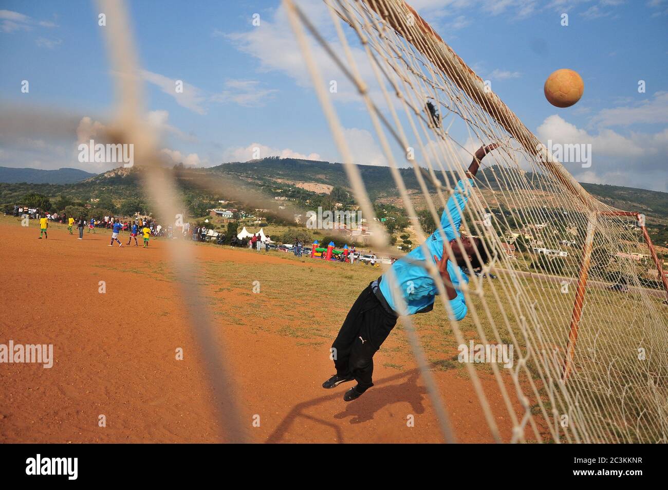 A goalkeeper makes a daring save during a football match in Limpopo, South Africa Stock Photo