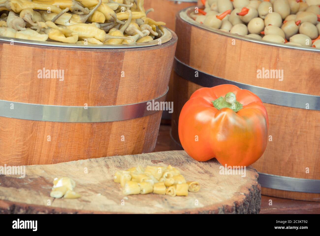Fresh green olives and peppers in wooden barrels. Healthy food