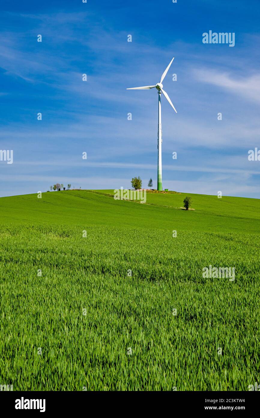 Agricultural landscape with a wind turbine in the distance Stock Photo