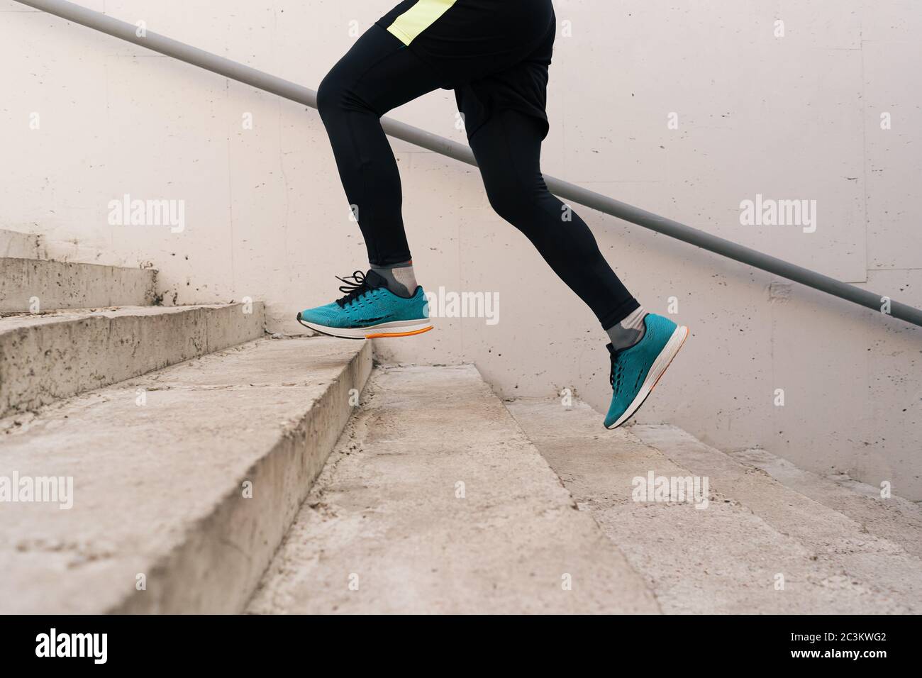 Young man legs running upstairs on city stairs. Fitness, sport, people, exercising and lifestyle concept Stock Photo