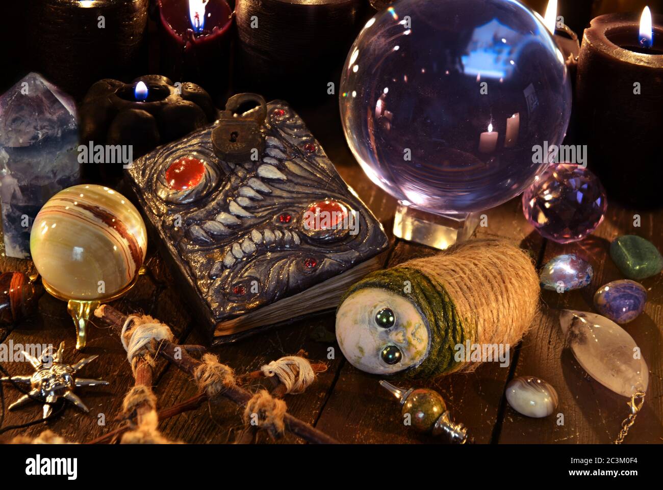 Scary voodoo doll, book with black magic spells and crystals on witch  table. Wicca, esoteric and occult background with vintage magic objects for  myst Stock Photo - Alamy