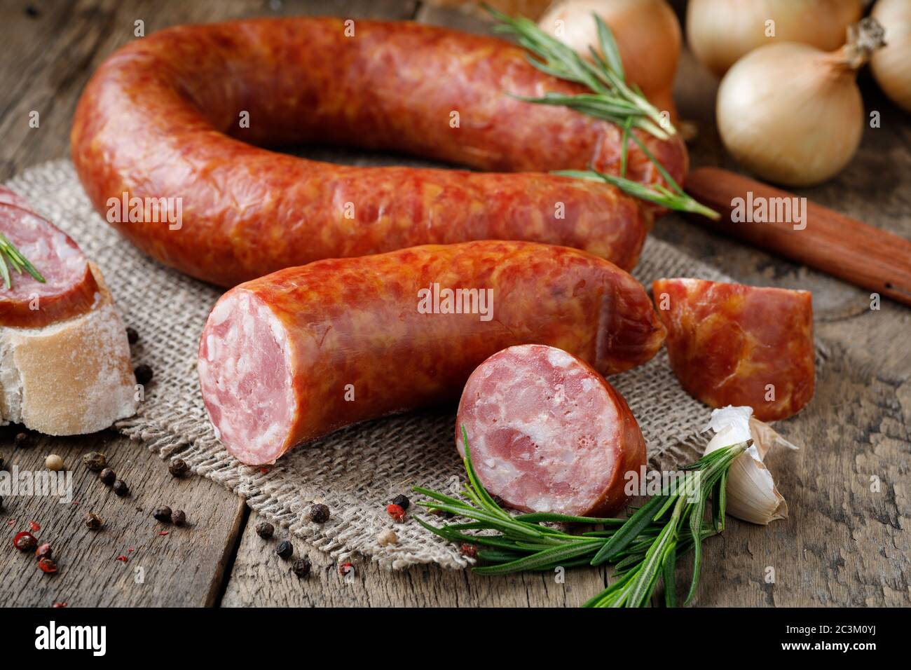 Smoked sausage on a wooden table. Rustic style. Stock Photo