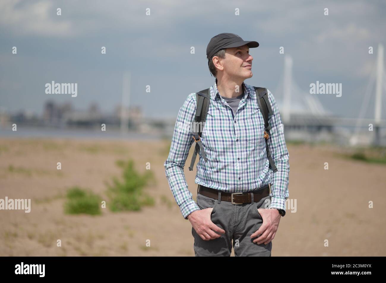 Alone mature Caucasian man with backpack standing at the beach in St. Petersburg, Russia Stock Photo