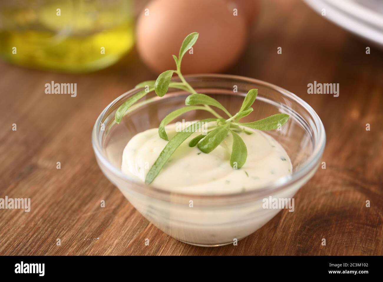 Bowl of mayonnaise with tarragon leaves Stock Photo