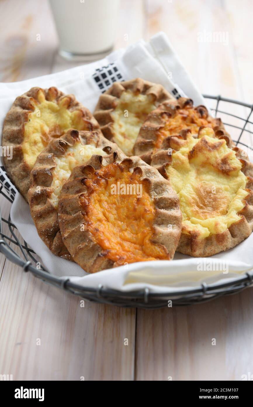 Karelian pasties with potato, carrot, and rice on a rustic table Stock Photo