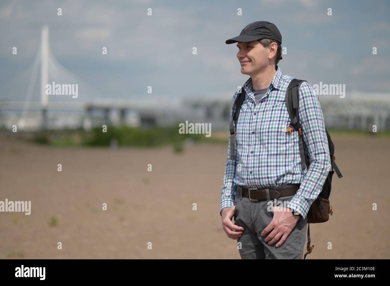 Alone mature Caucasian man with backpack standing at the beach in St. Petersburg, Russia Stock Photo