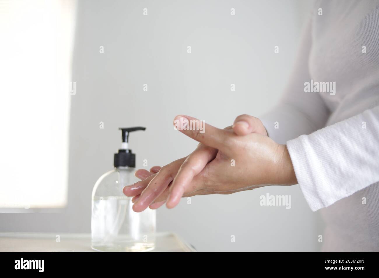 Washing hands by alcohol sanitizers or alcohol gel from pump bottle ...