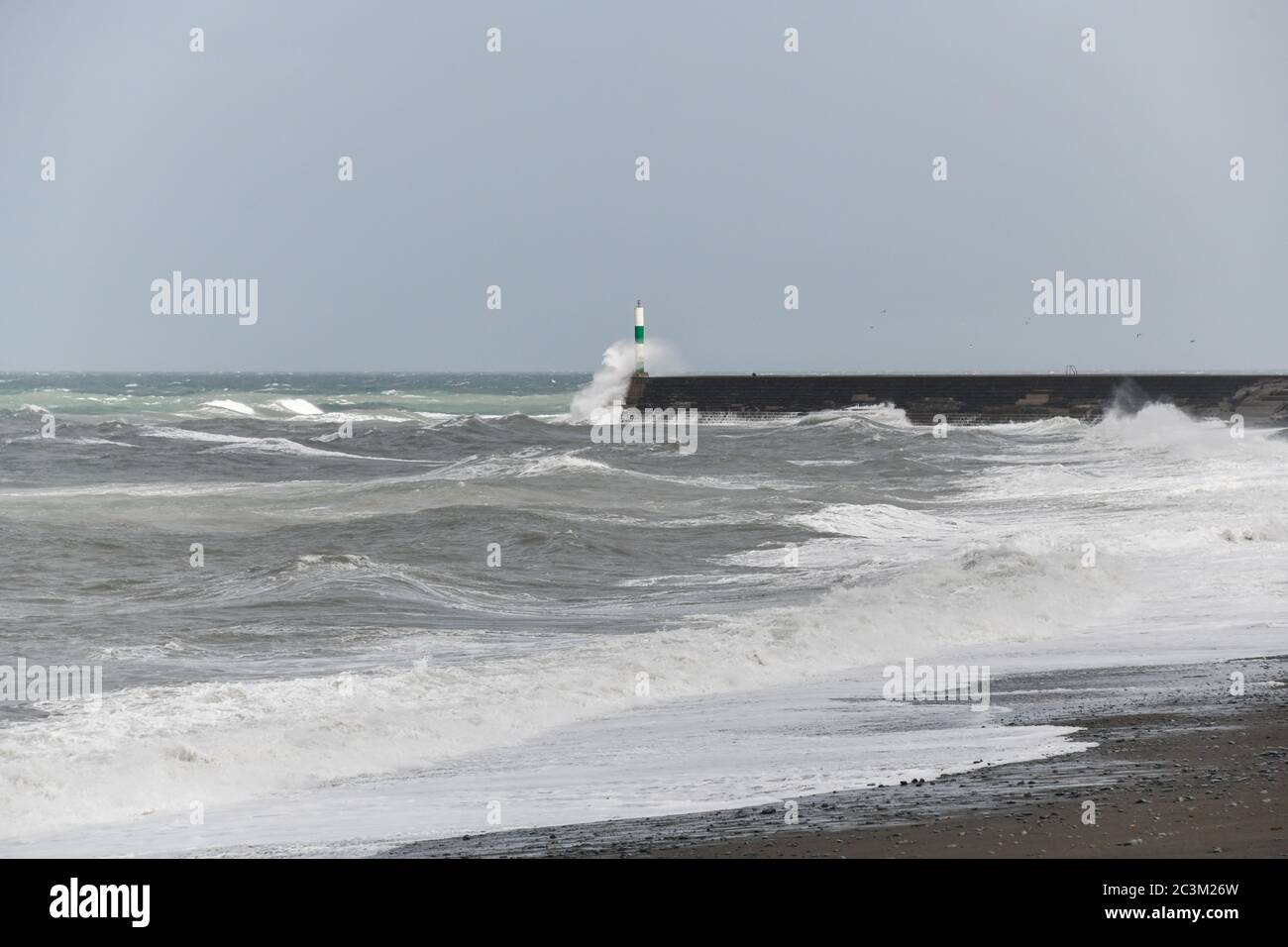 Harbour light at the end of the stone jetty at Aberystwyth Cardigan Bay West Wales looking north from Tanybwlch Stock Photo