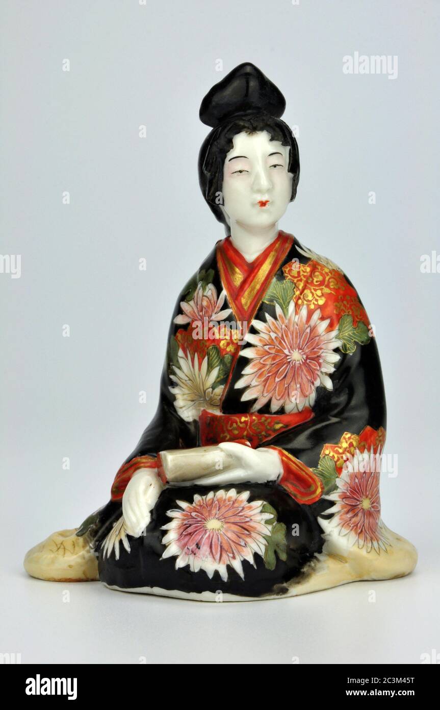Japanese porcelain Meiji bijin geisha okimono  in traditional dress decorated with chrysanthemums. Stock Photo