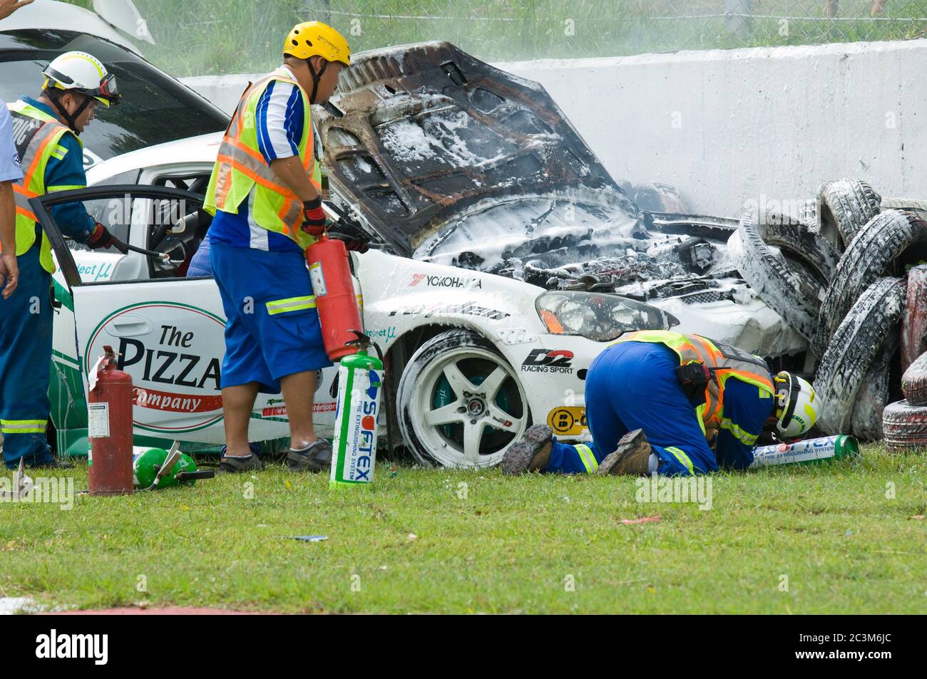 PATTAYA - JUNE 17: Rescue workers extinguish a fire in a wrecked Honda Integra during a touring car race at Bira Circuit, Pattaya, Thailand on June 17 Stock Photo