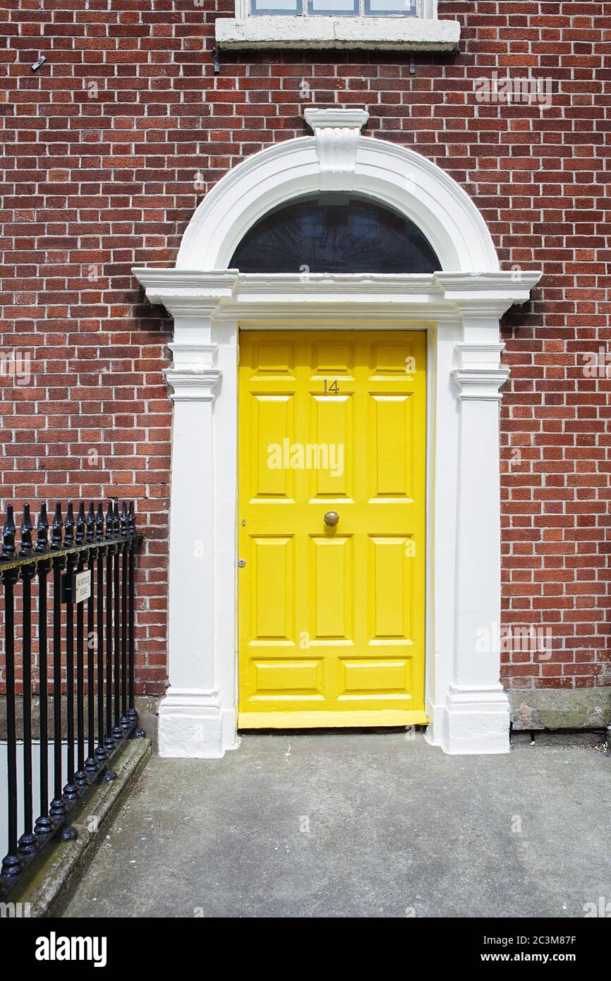 A yellow door in Dublin, Ireland. Arched door house front in