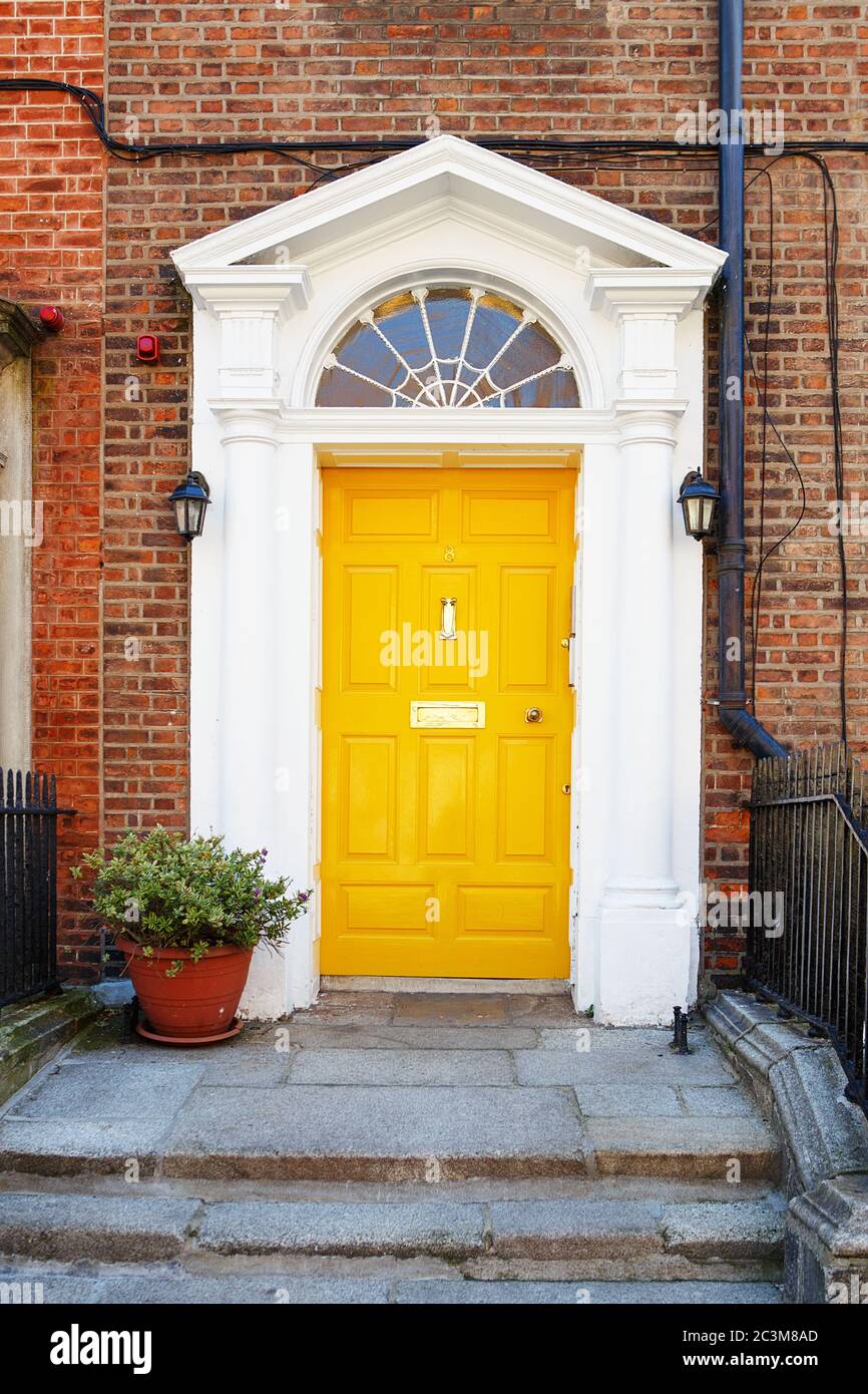 A yellow door in Dublin, Ireland. Arched door house front in