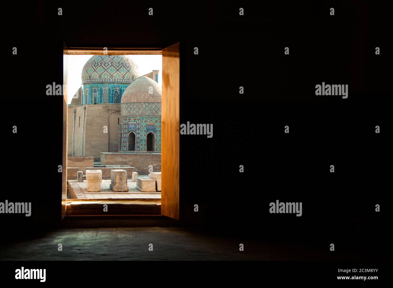 Open door in the dark room leading to the Shah-I-Zinda necropolis, a memorial complex cemetery in Samarkand, Uzbekistan Stock Photo