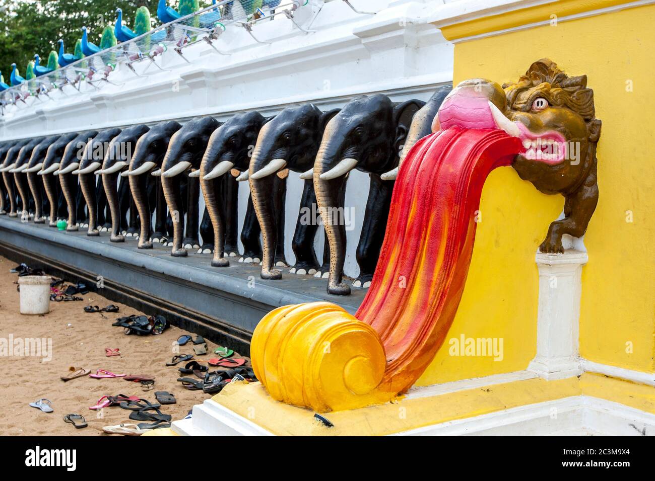 A dragon balustrade at the entrance wall to the main temple courtyard at Kataragama in southern Sri Lanka. Stock Photo