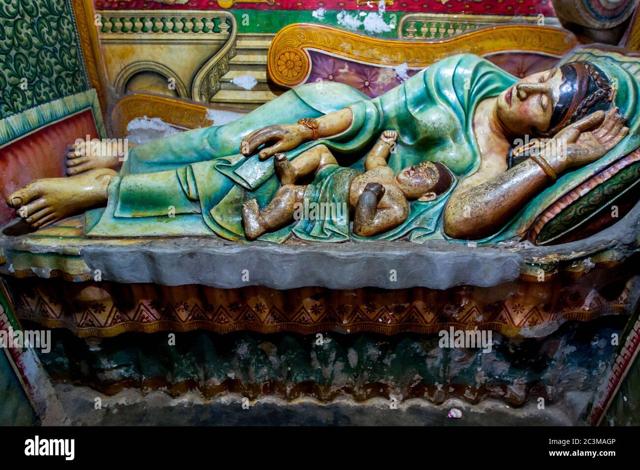 A statue showing the baby Lord Buddha laying with his mother in the Image House at Wewurukannala Vihara in Dickwella on the south coast of Sri Lanka. Stock Photo