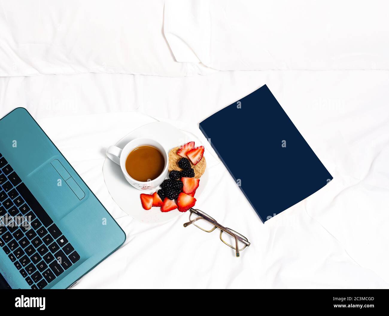 High angle shot of a cup of cappuccino with strawberries blackberries,  notebook and a laptop Stock Photo
