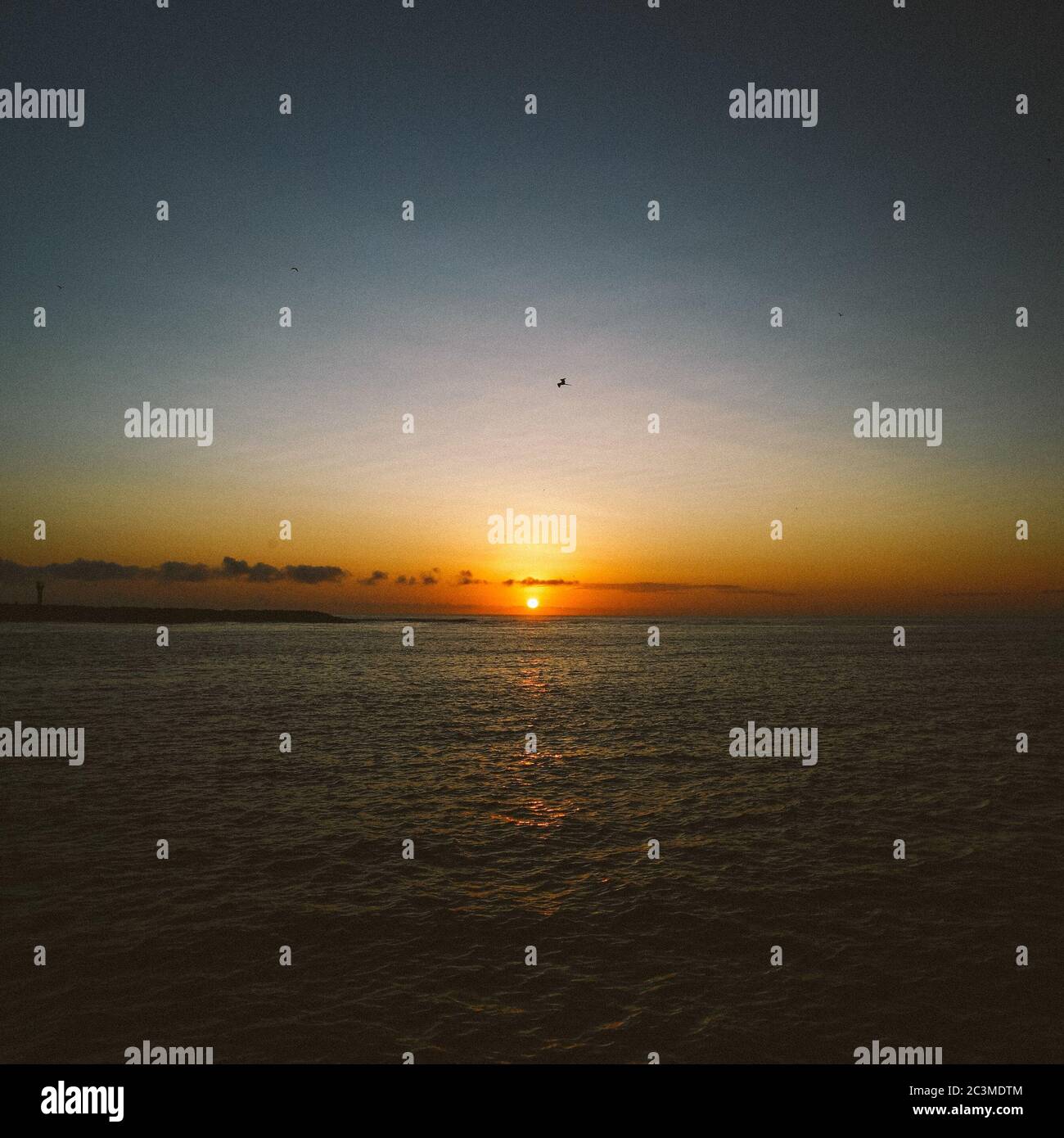 Beautiful scenery of a sunset reflecting in the sea Stock Photo - Alamy