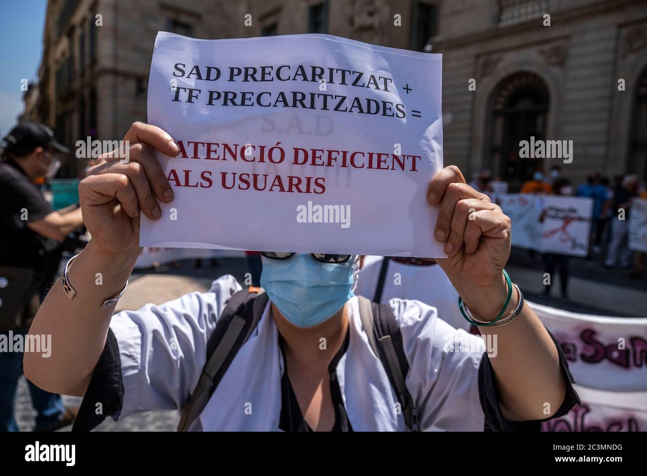 A protester wearing a facemask is seen showing a placard denouncing poor attention from public health services.Convened by the Marea Blanca collective, workers and users of public health have demonstrated against privatization and for the right to public health that truly serves people. Stock Photo