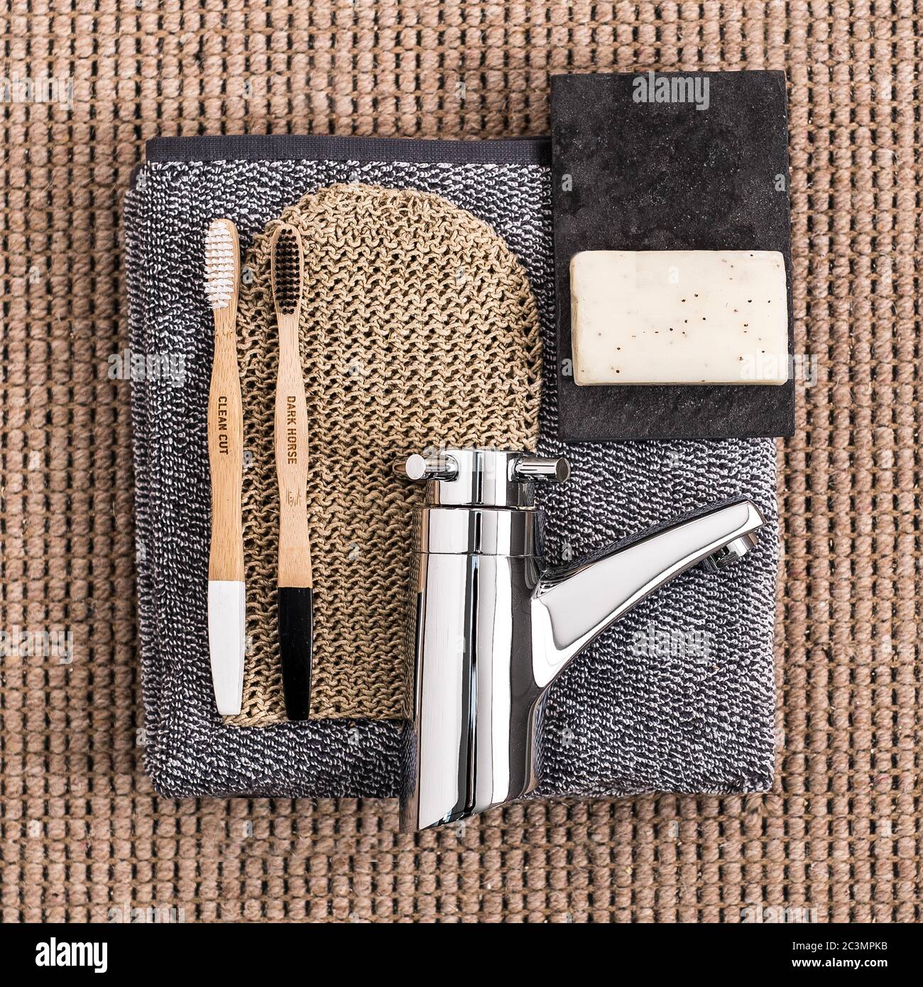 High angle shot of bathroom equipments soap, gray towel, two wooden toothbrushes and a silver top Stock Photo