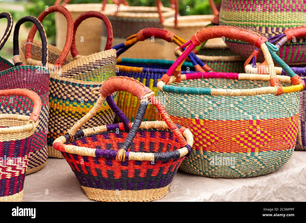 Colorful handwoven West African baskets at an outdoor market Stock