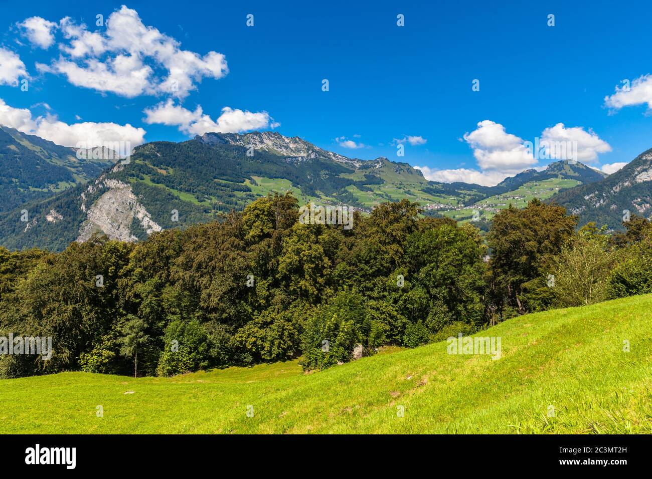 Idyllic view of Countryside in Switzerland with houses, mountain, meadow, near the Walensee lake, Canton of Glarus. lake, Canton of Glarus. Stock Photo