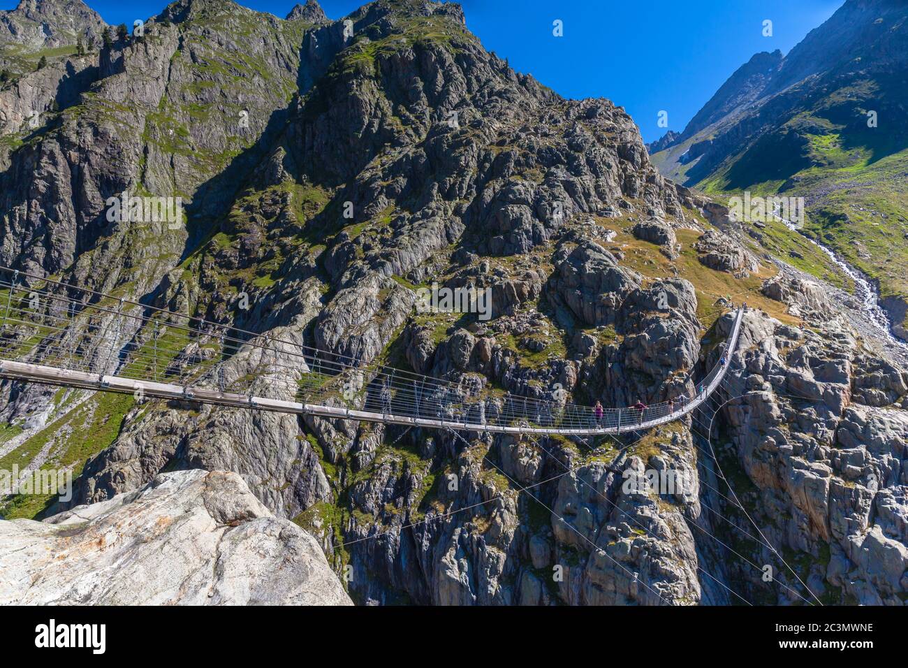 Stunning view of Trift bridge, a suspension bridge over the Triftsee, glacier, in Gimsel on Bernese Oberland, Switherland. Stock Photo