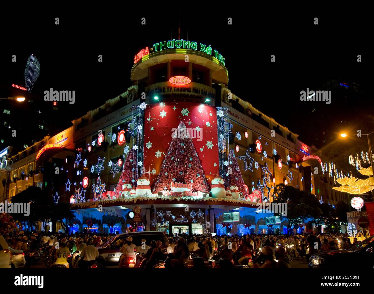 Thuong Xa Tax, the classic Saigon department store with Christmas decorations and shoppers in the street on December 22, 2010 in Ho Chi Minh City. Stock Photo