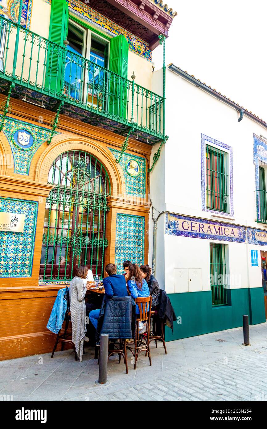 People eating al fresco at Alfarería 21 restaurant in restored Ceramica Artistica, M G Montalvan building in Triana, Calle Alfareria, Seville, Spain Stock Photo