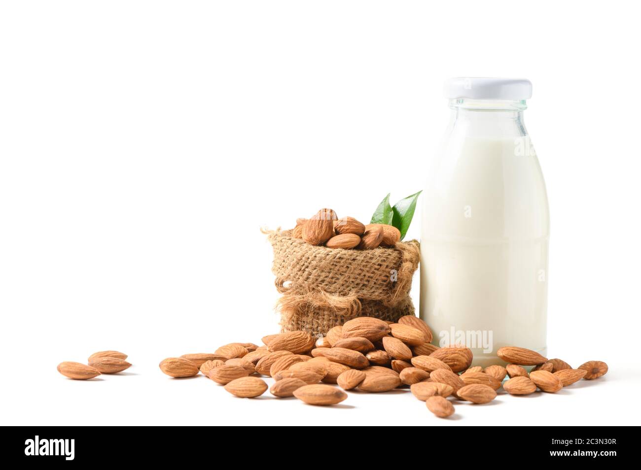 Bottle of milk and Almonds nuts with leaf isolated on white background, Almonds are very popular nuts and high protein . healthy food. Stock Photo