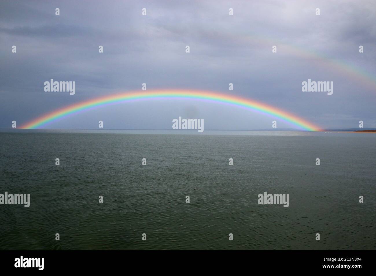 Full rainbow over the sea Stock Photo