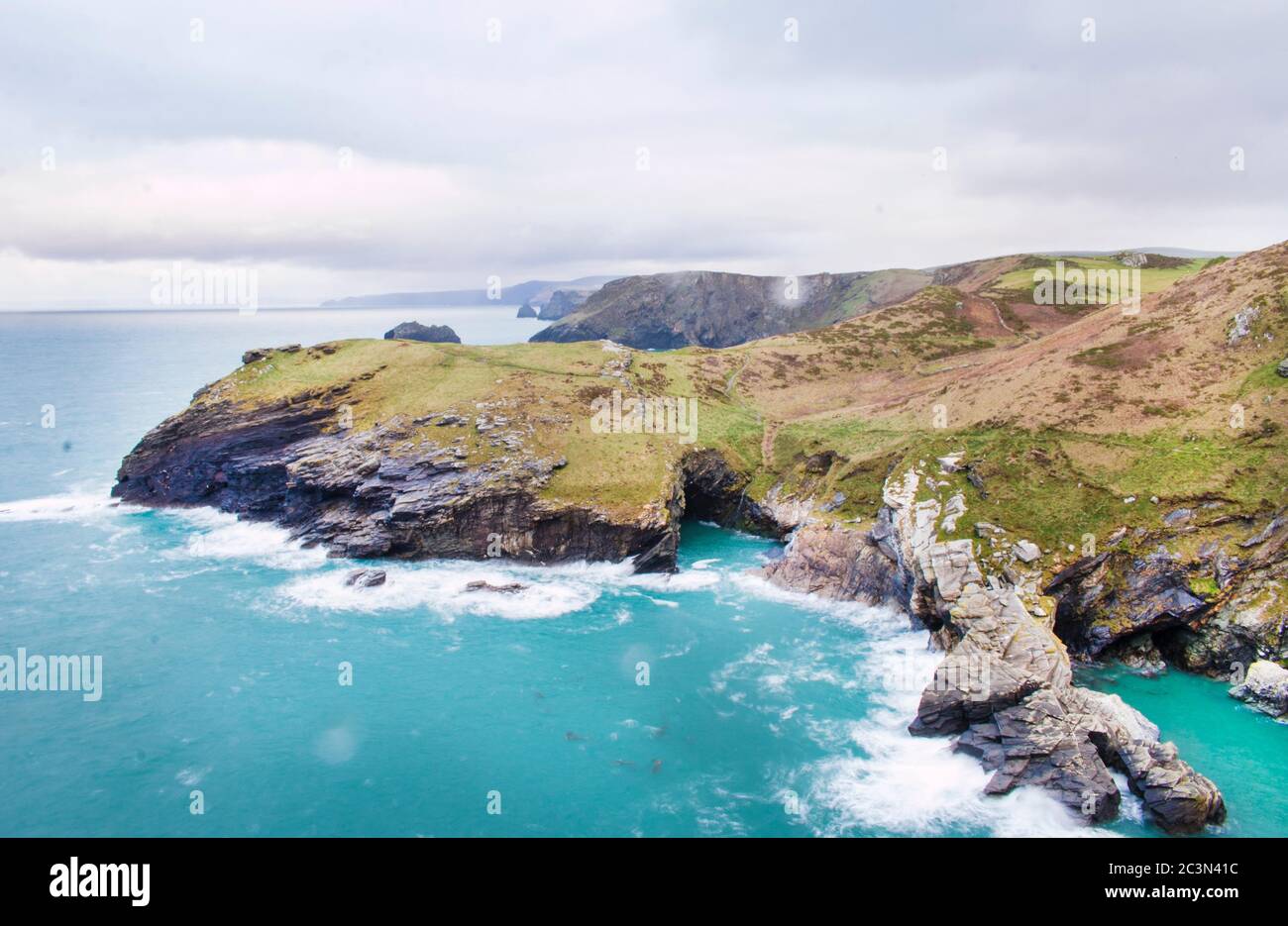 Landscape of cliffs covered in greenery surrounded by the sea under a ...