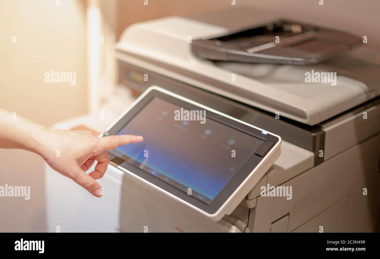 Female hand pressing the touchscreen monitor of the copy machine for