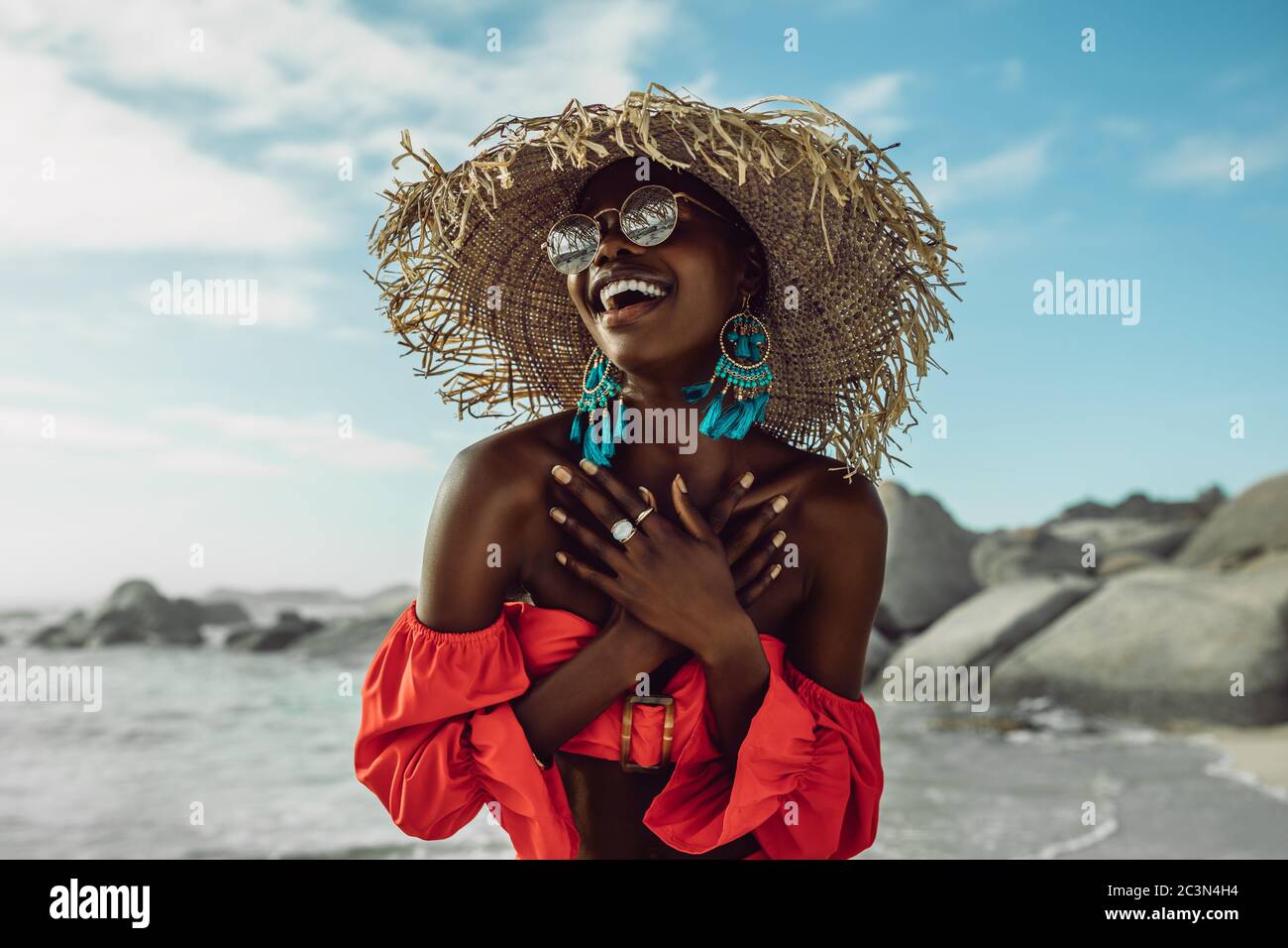 red dress wearing straw hat smiling 