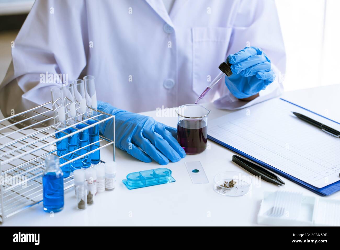 scientists researching in laboratory in white lab coat, gloves ...